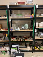 Front view of one shelving unit with various household items for display only, not included.