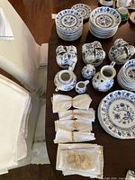 Overhead view of entire lot on table showing plates, cups, bowls, teapots, napkins and rings