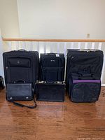 All six items displayed together: three large suitcases (Travelpro, Skyway, black with purple accent), one Martin F Weber carry-on, two briefcases (one with shoulder strap, one lockable metal)