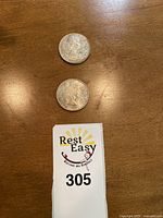 Photo showing both silver dollar coins from the obverse side with Queen Elizabeth II profile.