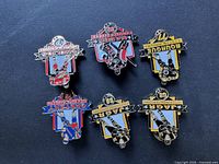 Photo showing all 6 vintage hockey pins laid out on a dark background, featuring players from Pittsburgh Penguins, Kamloops Blazers, Hershey Bears, and Binghamton Whalers.