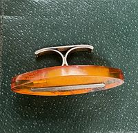 Top side view of the large oval faceted amber stone set in a sterling silver ring band, showing the thickness and color of the amber.