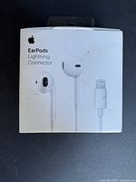 Front side of the sealed Apple EarPods box showing the product image and Lightning connector.