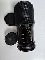 Full view of vintage Canon 70-210mm zoom lens with front and rear Canon lens caps showing overall condition and markings