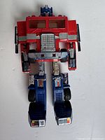 Optimus Prime figure in robot mode, showing front detail with red chest, blue legs and head