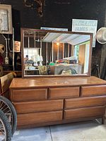 Front view of wooden 7-drawer dresser base with mirror attached
