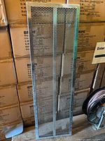 Full view of the metal mesh shelving unit showing the 6 shelves and mesh faces in silver metal.