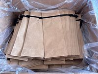 Open box showing multiple flat brown Kraft metalized bags with tin tie closures inside a plastic liner.