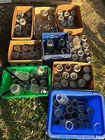 Overhead view of eight cardboard and plastic containers filled with clear glass jars