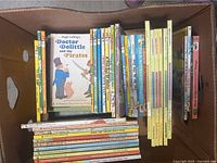 Box of assorted kids vintage books showing titles like Doctor Dolittle and the Pirates, colorful spines, various sizes.