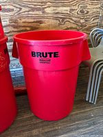 Front view of one red Rubbermaid Brute trash can showing the brand and model logos on the exterior.
