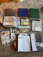 Wide shot of all scrapbooking materials laid out on floor, showing albums, papers, stickers, tools and accessories.