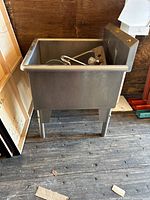 Front view of large stainless steel utility sink on legs