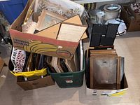 Large lot of assorted picture frames in boxes and containers, including framed and empty ones.