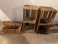Photo of two large wooden crates and several smaller wooden containers on concrete floor.