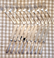 All 19 flatware pieces arranged on cloth showing condition and pattern