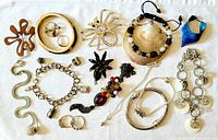 All 17 costume jewelry pieces laid out on fabric background