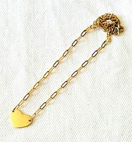 Full view of gold paperclip chain necklace with heart pendant