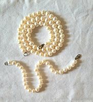 Pearl necklace and bracelet coiled to show pearls and clasps
