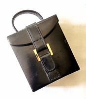 front view of black travel jewelry box with strap and clasp