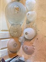 Group shot of all eight glass shades laid out on floor