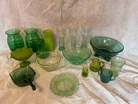 Entire lot of sixteen green glass items arranged together