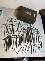 Hex keys spread out on tabletop with metal lockbox