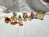 Group shot of all Cherished Teddies figurines and plaque on fabric backdrop