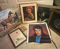 Group shot of six wall art pieces including Elvis poster, horse canvas, woman portrait print, Jesus print, small embroidery and framed clock