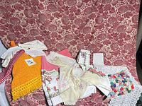 Group shot of assorted linens on red damask cloth backdrop
