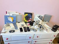 Overall lot showing devices, mice, chargers, manuals on dresser