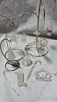 Group shot showing multiple clear blown glass ornaments on gold display stands