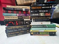Single image showing three stacks of over twenty English books in mixed formats
