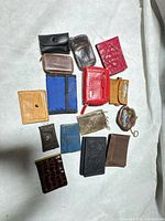 Group shot of all sixteen small wallets, coin purses and key pouches laid out