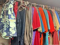 Clothing lot on hangers showing mix of shorts, pants, shirts, sweaters