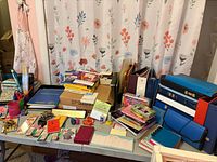 Wide view of table with binders, notebooks, sticky notes, pens, stapler, boxes
