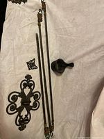 Overall lot view showing curtain rods, scroll plaque, butterfly hook, match holder