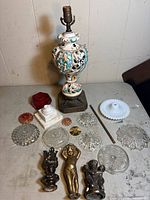 Overall lot showing ceramic lamp base, glass pieces, metal figures, marble block