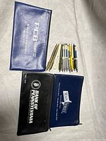 Group shot of three bank pouches, twelve pens and letter opener