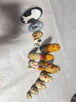 All 14 wooden nesting dolls in size order, open top example shown
