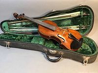 Violin in open hard shell case with two bows and interior green velvet lining
