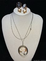 Full set displayed on bust: chain with pendant, earrings and rings.