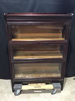 Front view of assembled bookcase with three barrister glass-front sections, base, and top cap.