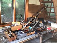 Overview of table with various hand tools and a long level across