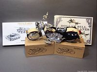 Two AUTOart 8-pot brake caliper tape dispensers in yellow and red, 1994 Buddy L Harley Davidson motorcycle, Metal Earth WWII tanks model, Sterling Innovation dollar bill fighter planes kit