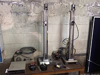 Two vertical mercurial barometer assemblies on metal bases alongside dewpoint sensor units and cables