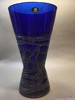 Front view of cobalt blue glass vase with textured abstract design and B.A.G. maker label