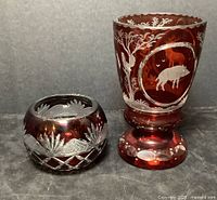 Chalice and mini rose bowl shown side by side, both ruby red cut crystal with intricate engravings and cuts