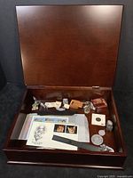 Open view of the wooden keepsake box with the assortment of stamps and small pewter figurines inside