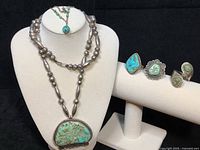 Full set displayed: necklace on bust, three rings on ring stand, necklace overlay